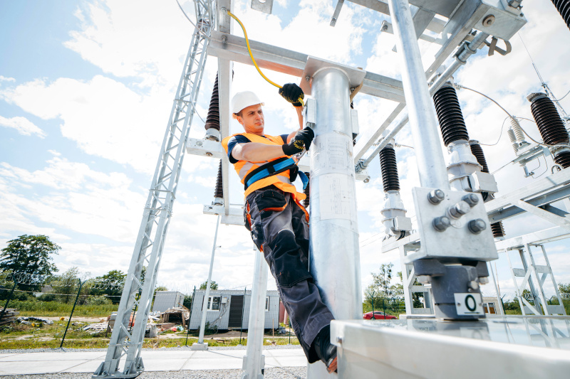 Elektriker arbeitet am Strommast